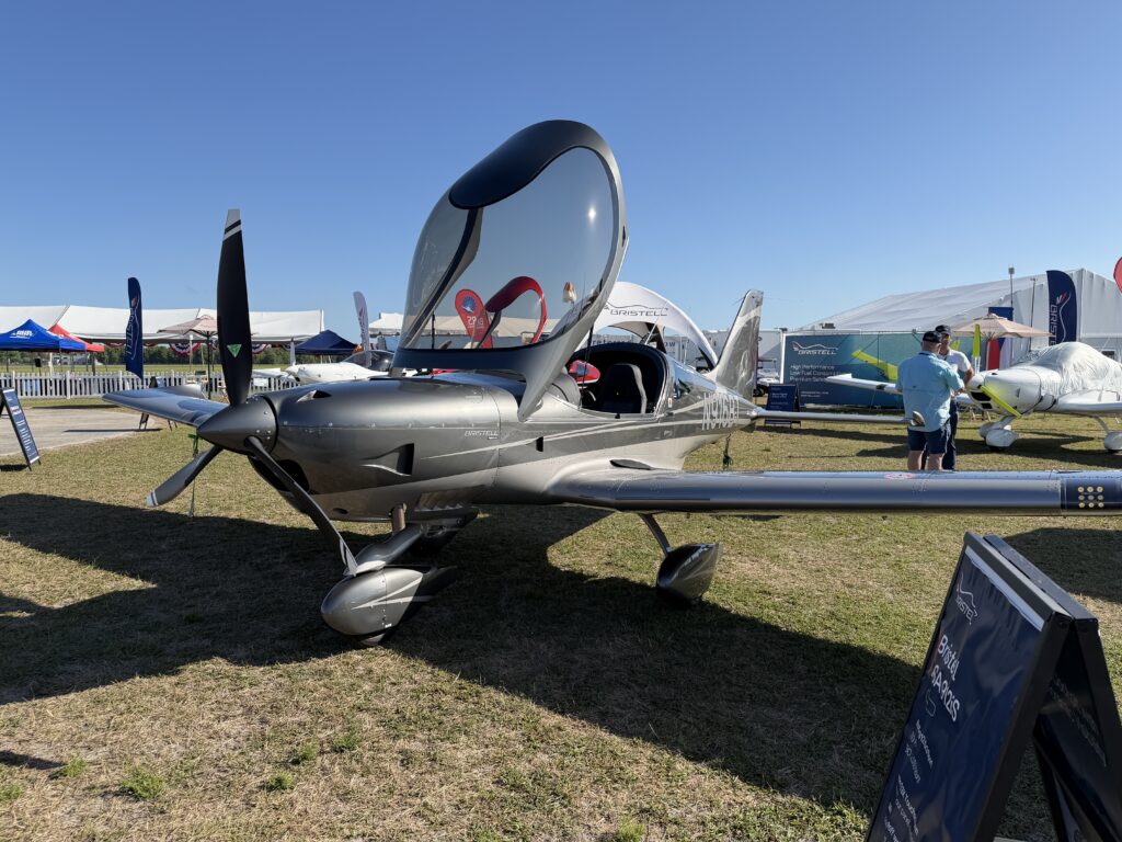 a silver and dark grey low wing Bristell B23 parked on the grass